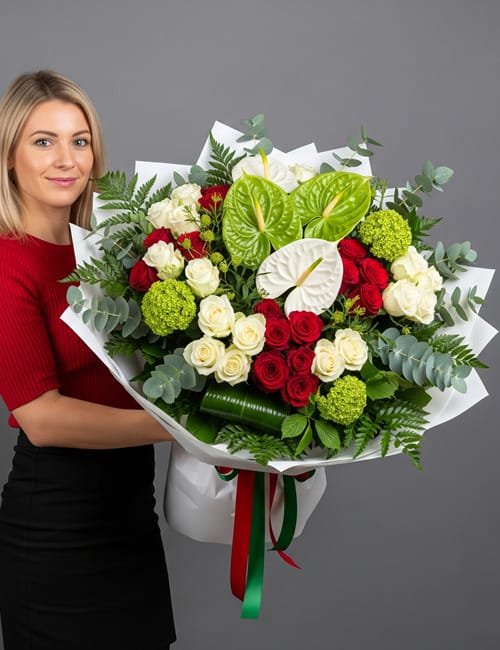 The "Forever Remembered" bouquet pictured includes Red Naomi Roses, Avalanche Roses, green and white Anthurium, Viburnum, Eucalyptus, Fern, and Aspidistra.