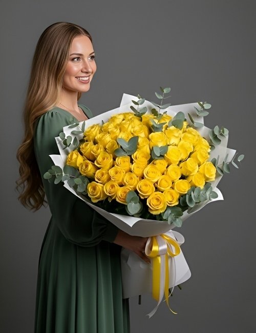 A woman holding 50 yellow roses in a bouquet